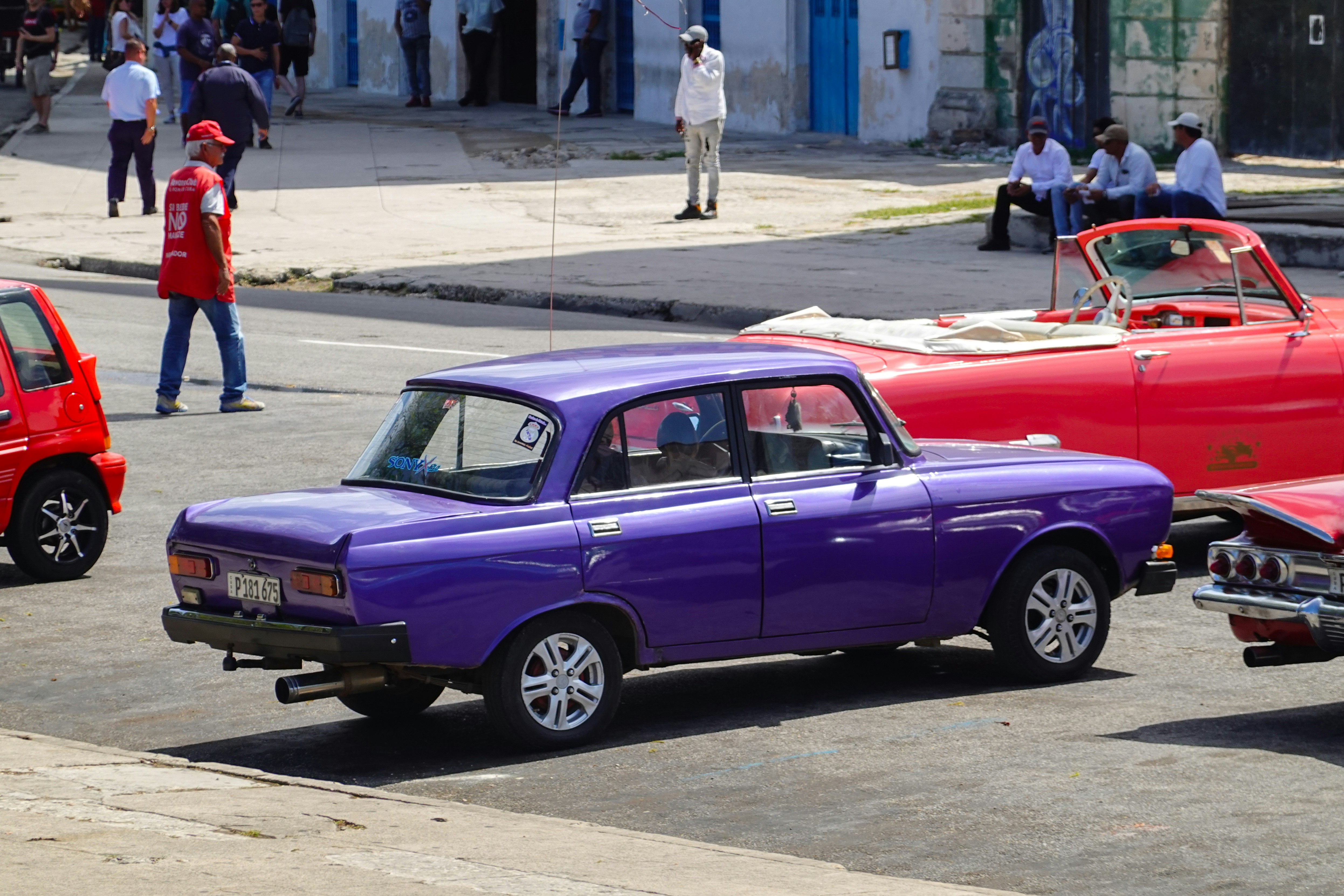 purple sedan on gray asphalt road during daytime